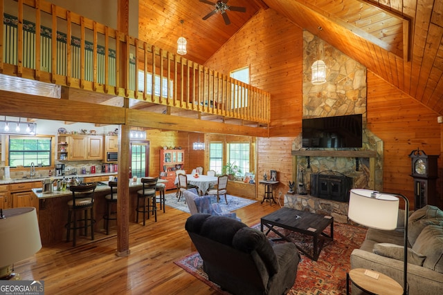 3382 Antioch Greggs Rd, Adel, GA 31620 - living area featuring high vaulted ceiling, plenty of natural light, light wood-type flooring, wood walls, and ceiling fan