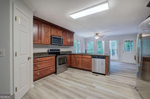 23 Timberlake Pointe NE, Cartersville, GA 30121 - kitchen with appliances with stainless steel finishes, a sink, a peninsula, dark stone counters, and a textured ceiling