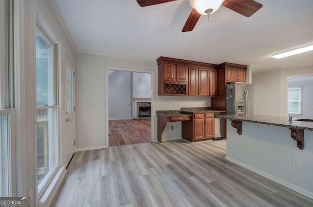 23 Timberlake Pointe NE, Cartersville, GA 30121 - kitchen featuring a breakfast bar area, light wood finished floors, dark stone countertops, brown cabinets, and a ceiling fan
