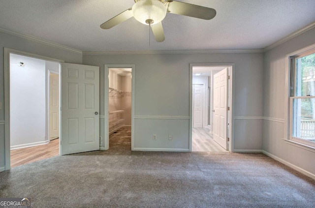 23 Timberlake Pointe NE, Cartersville, GA 30121 - unfurnished bedroom with carpet flooring, multiple windows, a spacious closet, a textured ceiling, and crown molding