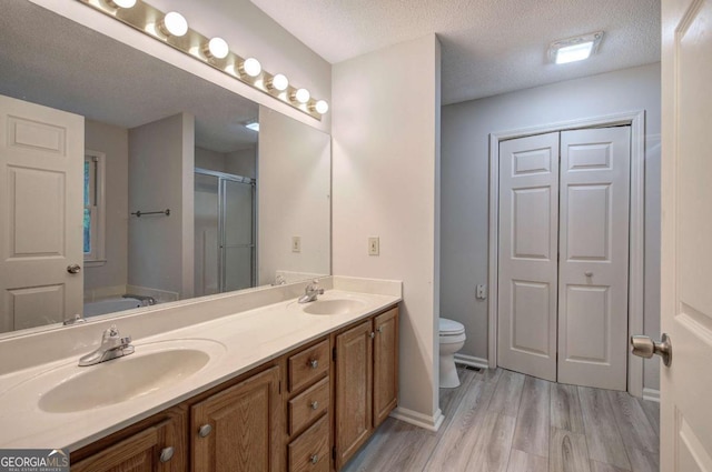 23 Timberlake Pointe NE, Cartersville, GA 30121 - full bathroom featuring wood finished floors, double vanity, a stall shower, a bath, and a textured ceiling