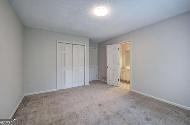 23 Timberlake Pointe NE, Cartersville, GA 30121 - unfurnished bedroom with light colored carpet, a closet, a textured ceiling, and ensuite bathroom
