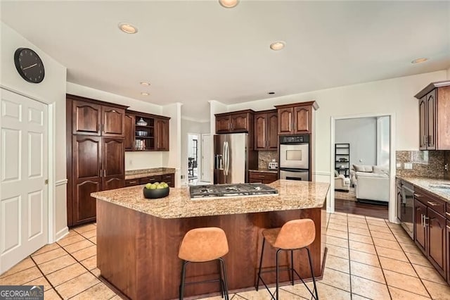 5940 Plantation Dr, Roswell, GA 30075 - kitchen featuring appliances with stainless steel finishes, light tile patterned flooring, tasteful backsplash, a center island, and recessed lighting