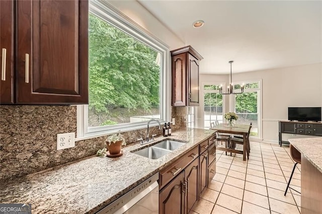 5940 Plantation Dr, Roswell, GA 30075 - kitchen featuring a sink, backsplash, light stone counters, and light tile patterned floors