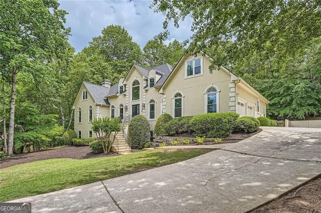 5940 Plantation Dr, Roswell, GA 30075 - view of front of house with concrete driveway, stucco siding, a front lawn, and an attached garage