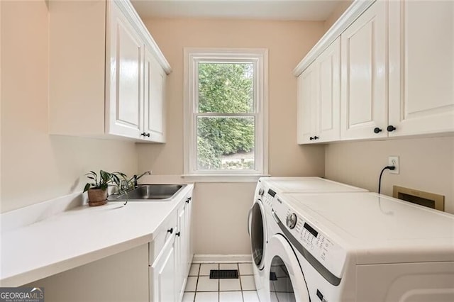 5940 Plantation Dr, Roswell, GA 30075 - laundry area with cabinet space, washing machine and clothes dryer, baseboards, and light tile patterned flooring