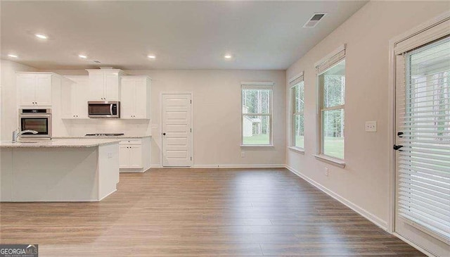 165 Cooper Cv E, Fayetteville, GA 30215 - kitchen with appliances with stainless steel finishes, wood finished floors, white cabinetry, and recessed lighting