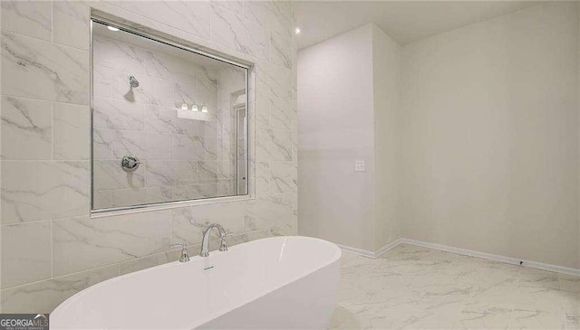 165 Cooper Cv E, Fayetteville, GA 30215 - bathroom featuring marble finish floors, a freestanding tub, and baseboards