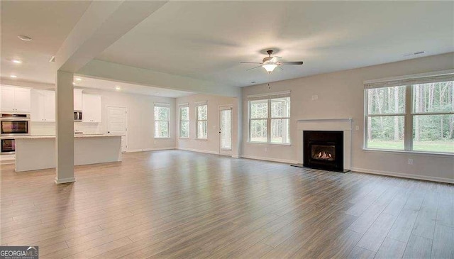 165 Cooper Cv E, Fayetteville, GA 30215 - unfurnished living room featuring a ceiling fan, wood finished floors, baseboards, a lit fireplace, and recessed lighting
