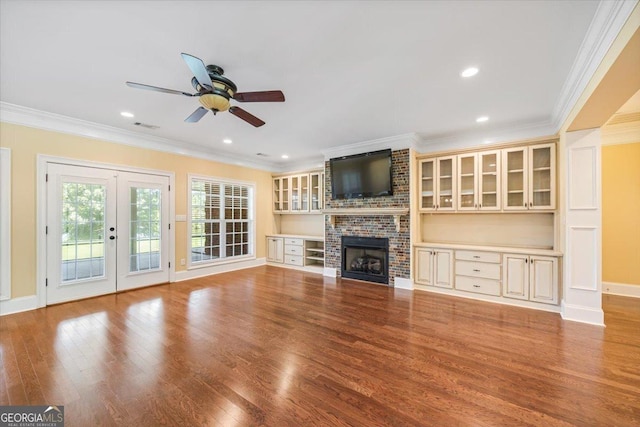 737 Raleigh Cobb Rd, Hawkinsville, GA 31036 - unfurnished living room featuring a ceiling fan, crown molding, wood finished floors, a brick fireplace, and french doors