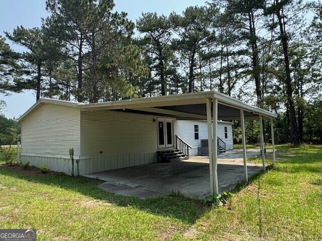 12103 US Highway 80 E, Brooklet, GA 30415 - back of house featuring entry steps, a lawn, a carport, and a patio area