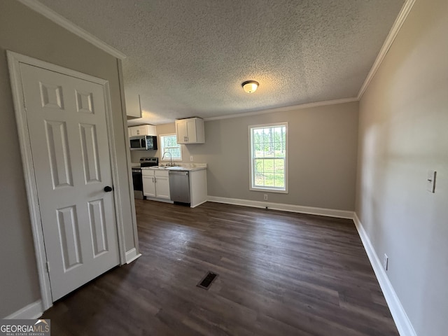 12103 US Highway 80 E, Brooklet, GA 30415 - kitchen featuring appliances with stainless steel finishes, ornamental molding, light countertops, white cabinetry, and dark wood-style floors