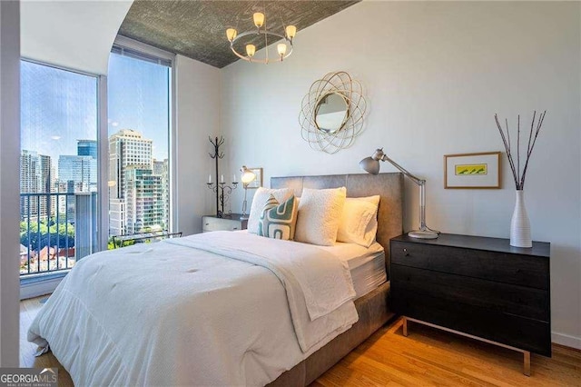 860 Peachtree St NE Unit 1613, Atlanta, GA 30308 - bedroom with wood finished floors, a chandelier, and a city view