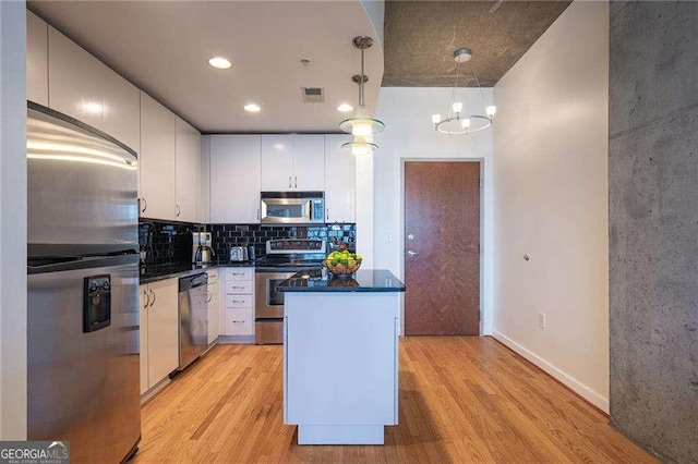 860 Peachtree St NE Unit 1613, Atlanta, GA 30308 - kitchen with stainless steel appliances, light wood-type flooring, a center island, dark countertops, and recessed lighting