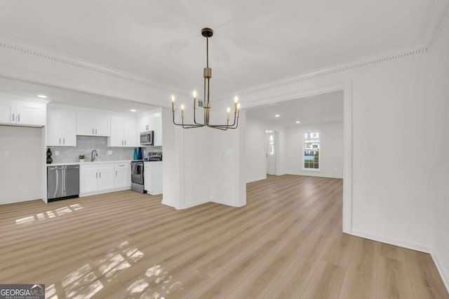 1 N Boundary Pl NW, Atlanta, GA 30318 - kitchen featuring appliances with stainless steel finishes, a chandelier, open floor plan, light wood finished floors, and light countertops