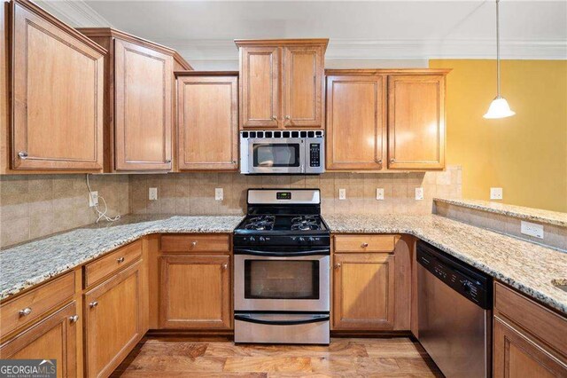 100 Trailside Way, Hiram, GA 30141 - kitchen featuring appliances with stainless steel finishes, crown molding, decorative backsplash, light wood finished floors, and brown cabinets