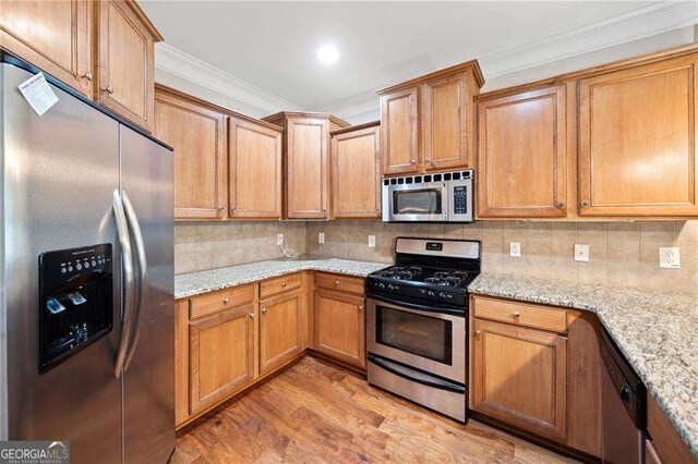 100 Trailside Way, Hiram, GA 30141 - kitchen with stainless steel appliances, light wood-type flooring, crown molding, backsplash, and light stone countertops