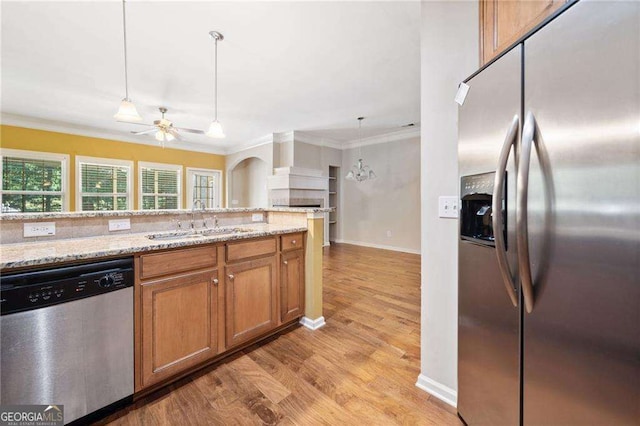 100 Trailside Way, Hiram, GA 30141 - kitchen featuring stainless steel appliances, ornamental molding, light wood-type flooring, a sink, and brown cabinetry