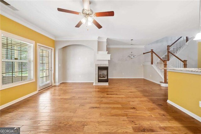 100 Trailside Way, Hiram, GA 30141 - unfurnished living room featuring light wood-style flooring, a ceiling fan, crown molding, a fireplace, and stairway