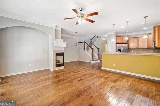 100 Trailside Way, Hiram, GA 30141 - unfurnished living room with crown molding, ceiling fan, stairs, wood-type flooring, and baseboards