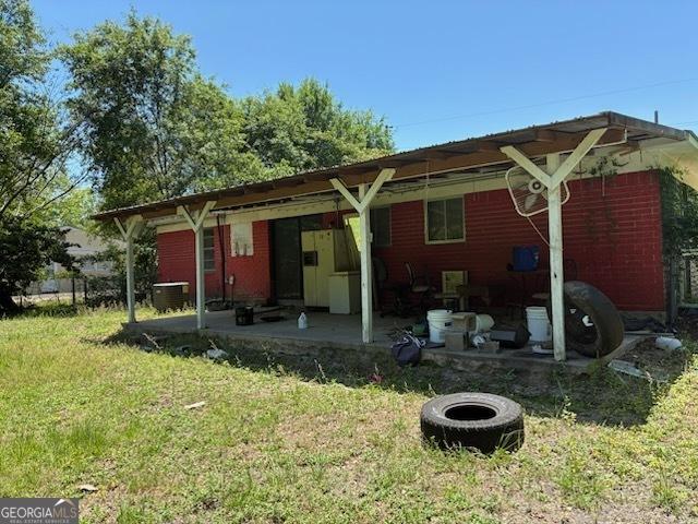306 Greenview St, Jesup, GA 31545 - rear view of house with a yard, a patio area, and central AC