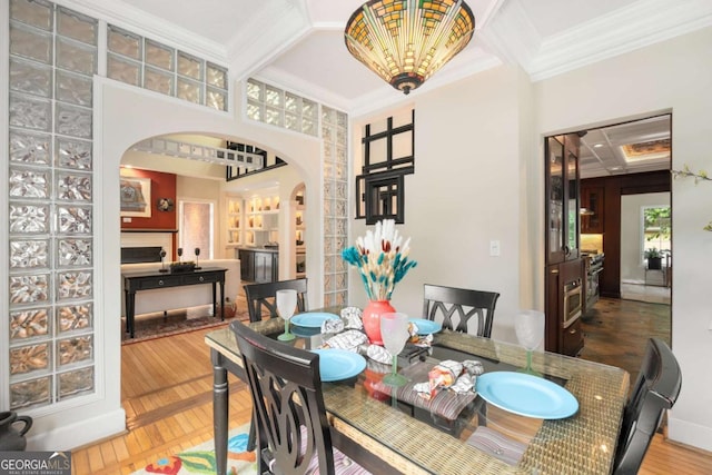 228 Clarion Ave, Decatur, GA 30030 - dining space featuring arched walkways, ornamental molding, coffered ceiling, a high ceiling, and wood finished floors