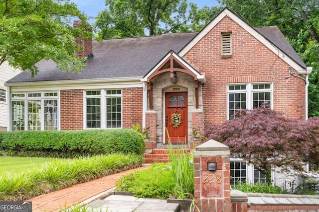 228 Clarion Ave, Decatur, GA 30030 - view of front of house featuring a chimney, roof with shingles, and brick siding