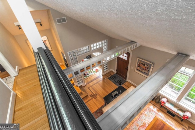 228 Clarion Ave, Decatur, GA 30030 - stairway featuring lofted ceiling, a textured ceiling, and wood finished floors