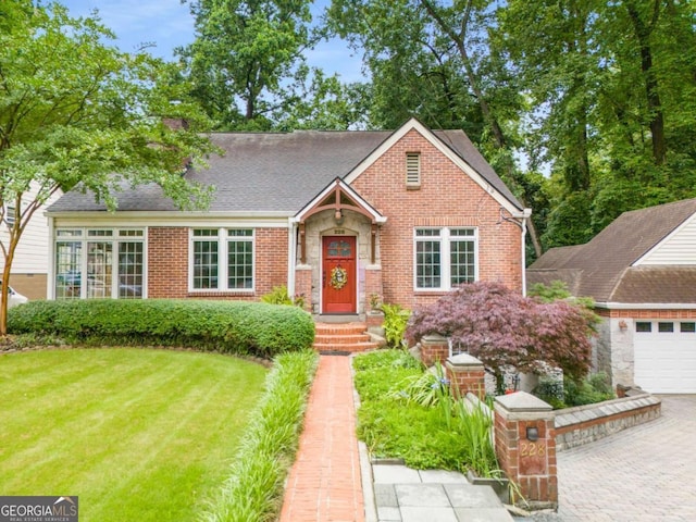 228 Clarion Ave, Decatur, GA 30030 - view of front of house with a front yard, brick siding, roof with shingles, and driveway