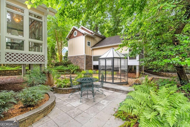 228 Clarion Ave, Decatur, GA 30030 - view of patio / terrace featuring a greenhouse and an outbuilding