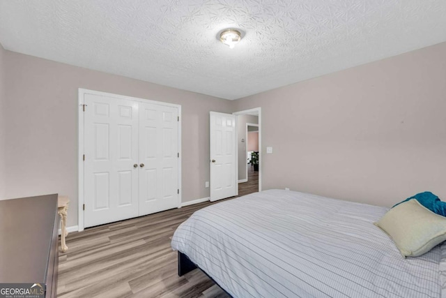 502 Stoneland Pl, Lawrenceville, GA 30046 - bedroom with wood finished floors, a closet, baseboards, and a textured ceiling