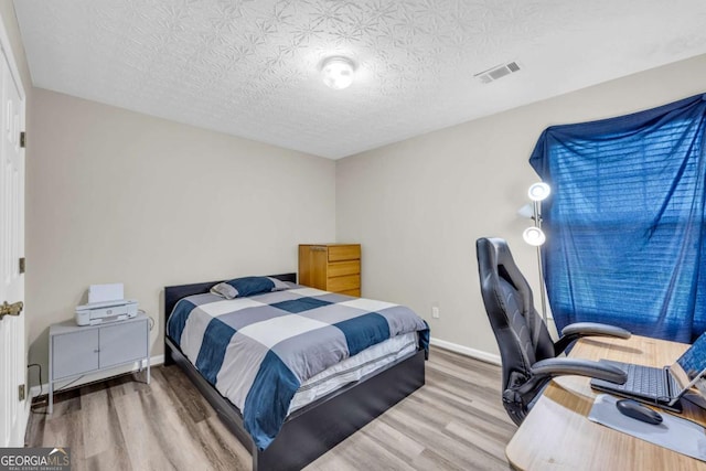502 Stoneland Pl, Lawrenceville, GA 30046 - bedroom featuring wood finished floors, a textured ceiling, and a desk