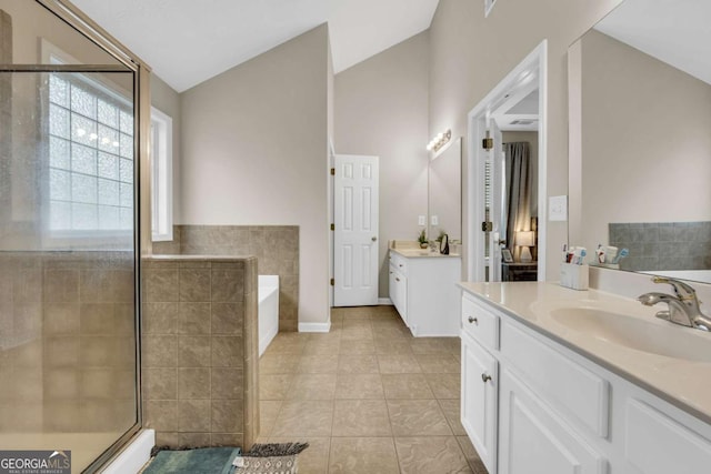 502 Stoneland Pl, Lawrenceville, GA 30046 - full bath featuring two vanities, a garden tub, a stall shower, tile patterned flooring, and lofted ceiling
