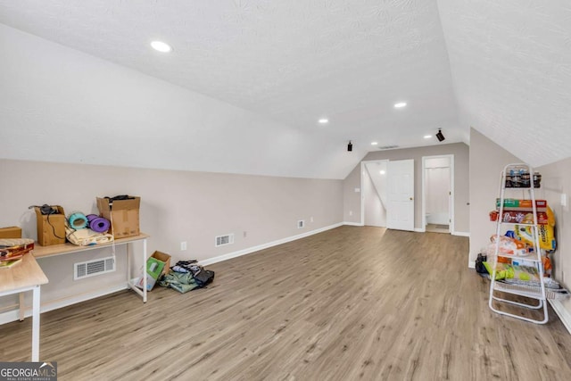 502 Stoneland Pl, Lawrenceville, GA 30046 - playroom with wood finished floors, vaulted ceiling, a textured ceiling, and baseboards