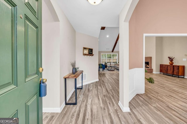 502 Stoneland Pl, Lawrenceville, GA 30046 - entryway featuring arched walkways, light wood-style floors, a brick fireplace, and baseboards