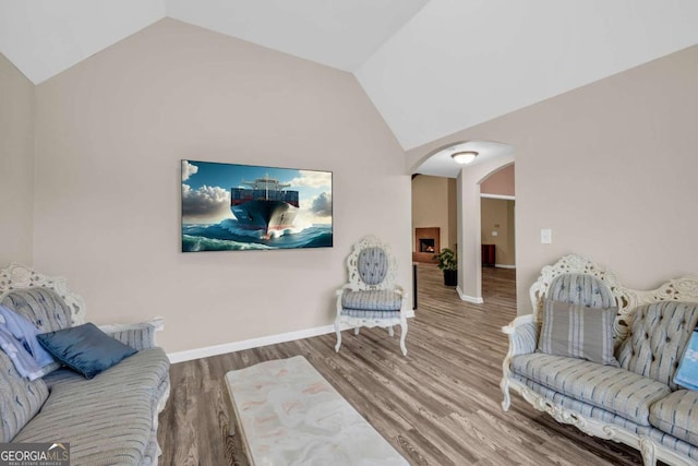 502 Stoneland Pl, Lawrenceville, GA 30046 - living room featuring arched walkways, vaulted ceiling, and wood finished floors