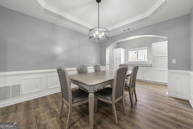 1535 Fenmore St, Lithia Springs, GA 30122 - dining space featuring a tray ceiling, arched walkways, crown molding, wainscoting, and a chandelier