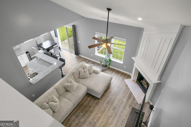 1535 Fenmore St, Lithia Springs, GA 30122 - living room with a fireplace with flush hearth, ceiling fan, wood finished floors, and lofted ceiling