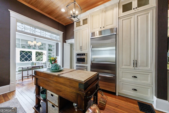 381 Cherokee Ave SE, Atlanta, GA 30312 - kitchen featuring stainless steel appliances, a chandelier, light wood-type flooring, wood ceiling, and hanging light fixtures