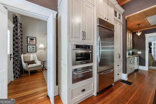 381 Cherokee Ave SE, Atlanta, GA 30312 - kitchen with stainless steel appliances, a warming drawer, dark wood-type flooring, glass insert cabinets, and white cabinets