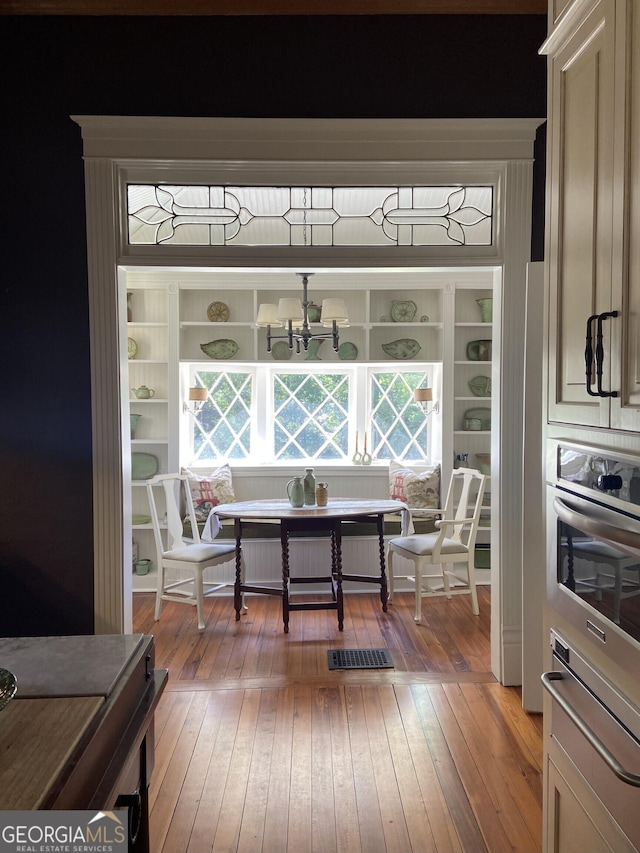381 Cherokee Ave SE, Atlanta, GA 30312 - dining space featuring light wood-style flooring, a chandelier, and radiator