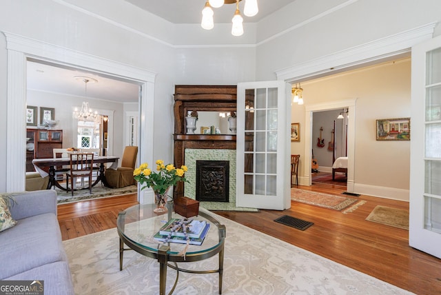 381 Cherokee Ave SE, Atlanta, GA 30312 - living area featuring a chandelier, wood finished floors, a fireplace with flush hearth, ornamental molding, and a towering ceiling