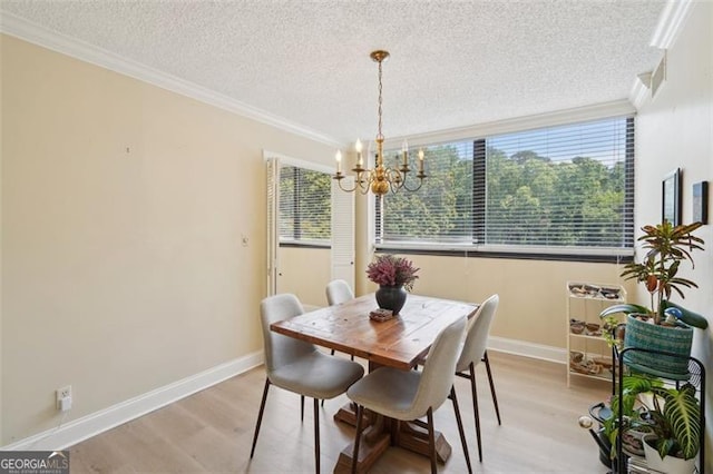 3530 Piedmont Rd NE Unit 2I, Atlanta, GA 30305 - dining area with light wood-type flooring, ornamental molding, a textured ceiling, and a chandelier
