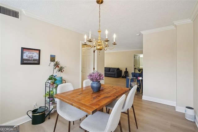 3530 Piedmont Rd NE Unit 2I, Atlanta, GA 30305 - dining room with a chandelier, light wood finished floors, ornamental molding, and a textured ceiling