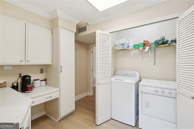 3530 Piedmont Rd NE Unit 2I, Atlanta, GA 30305 - washroom featuring washer and clothes dryer, ornamental molding, and light wood-style flooring