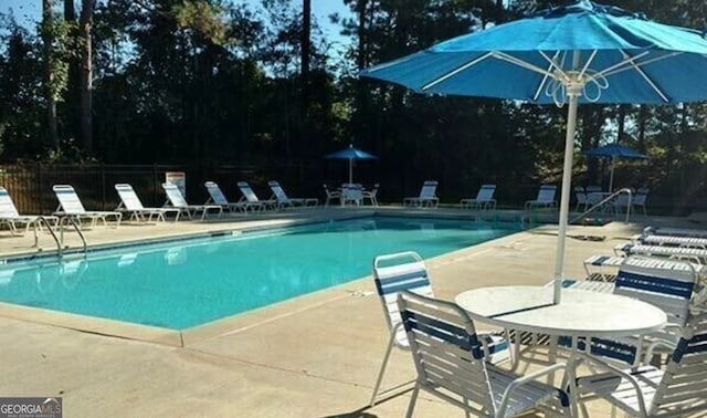 131 Bob White Ln, Newnan, GA 30263 - community pool featuring a patio area and view of wooded area