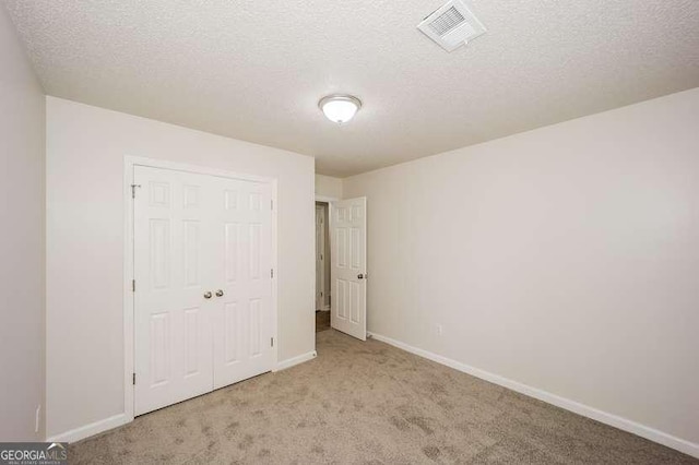 4112 Meadowlark Ct, Powder Springs, GA 30127 - unfurnished bedroom with light colored carpet, baseboards, a closet, and a textured ceiling