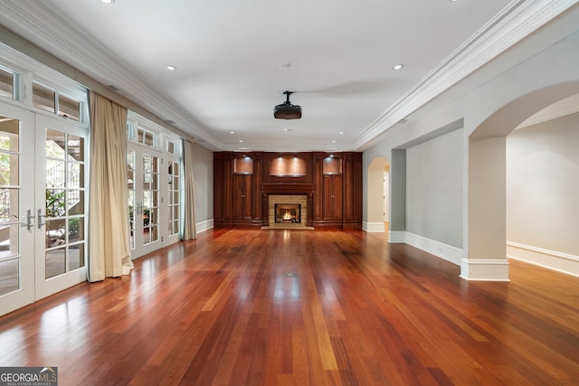 760 River Gate Dr, Atlanta, GA 30350 - unfurnished living room with arched walkways, french doors, wood finished floors, a glass covered fireplace, and crown molding