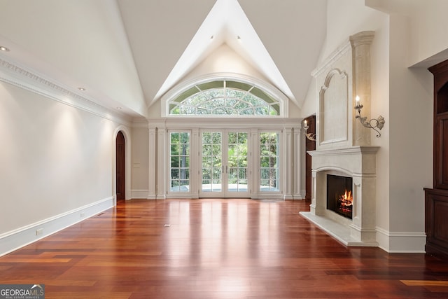 760 River Gate Dr, Atlanta, GA 30350 - unfurnished living room featuring a high end fireplace, wood finished floors, high vaulted ceiling, and arched walkways