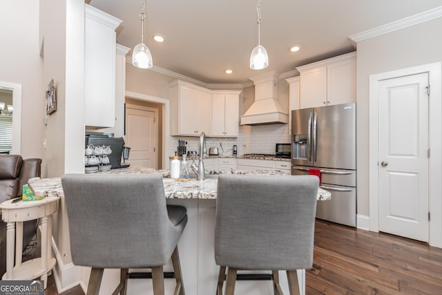 924 Abingdon Cv, Bonaire, GA 31005 - kitchen with stainless steel appliances, custom exhaust hood, backsplash, a peninsula, and white cabinetry